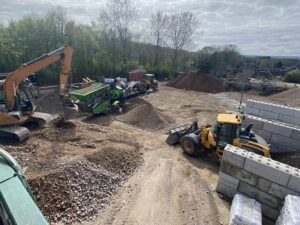A working aggregate yard, with various lorries and diggers.